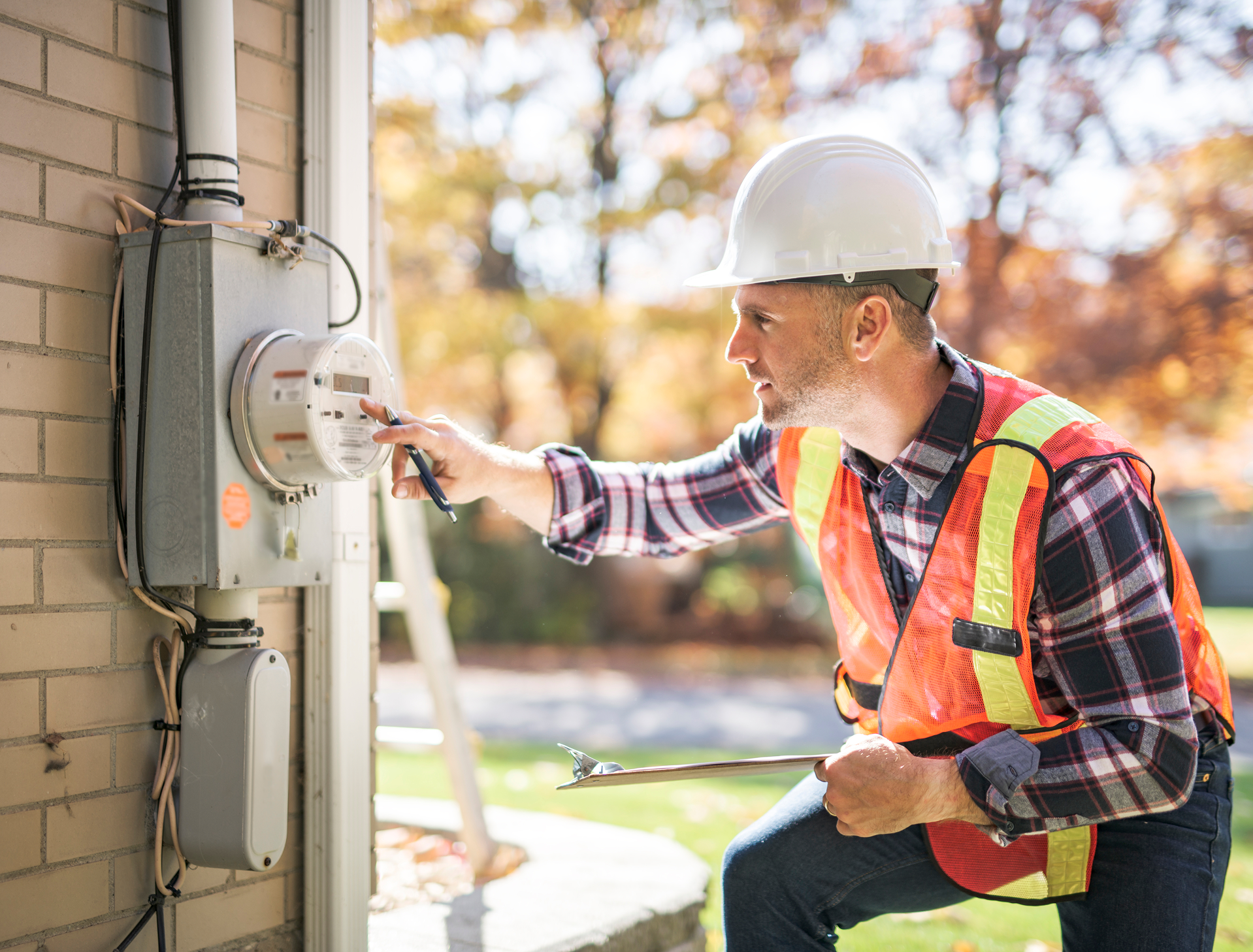 Worker checking electrical meter outside building